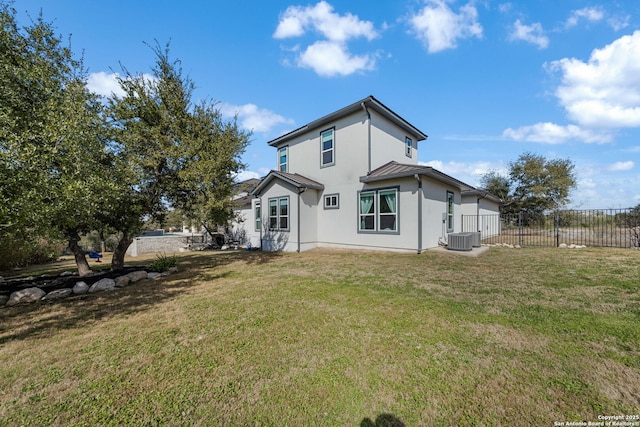 back of house with a lawn, metal roof, a standing seam roof, fence, and central AC