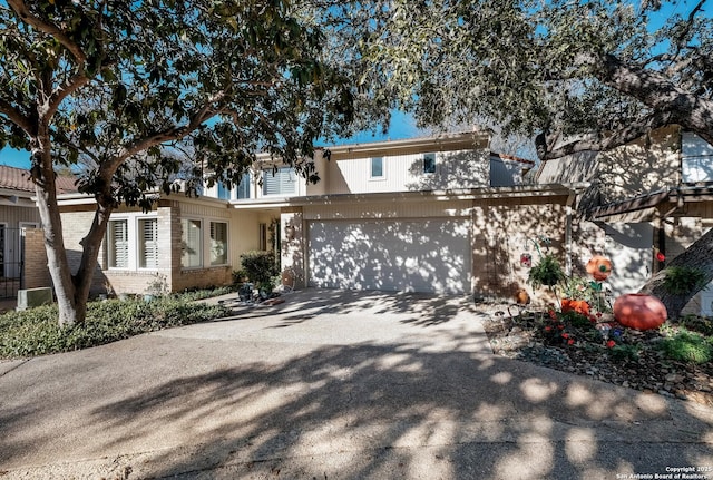 view of front of property featuring a garage, concrete driveway, and brick siding