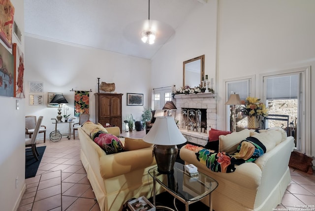 living area featuring visible vents, high vaulted ceiling, a stone fireplace, and light tile patterned flooring