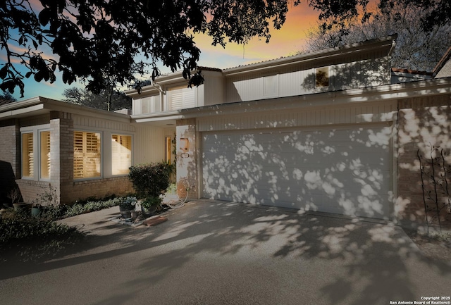 view of front of home with driveway and brick siding