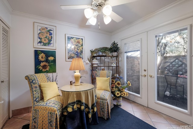 living area featuring a ceiling fan, baseboards, french doors, ornamental molding, and tile patterned floors