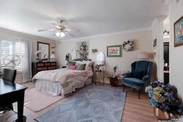 bedroom featuring light wood-type flooring, baseboards, ornamental molding, and a ceiling fan