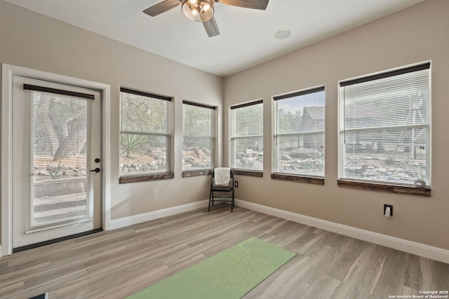 unfurnished sunroom featuring ceiling fan