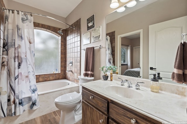 ensuite bathroom with toilet, shower / tub combo, vanity, ensuite bath, and wood finished floors