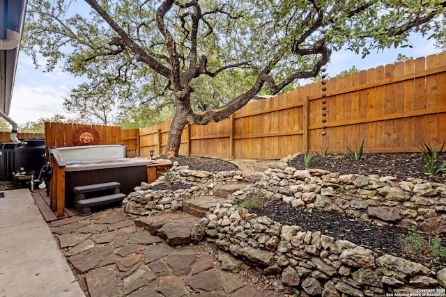 view of yard with a fenced backyard, a patio, and a hot tub