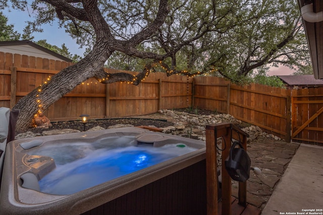 view of patio with fence and a hot tub