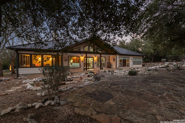 rear view of house featuring metal roof