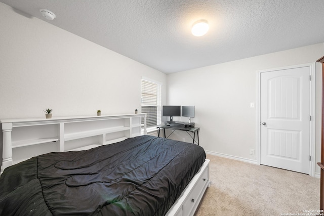 bedroom with carpet, baseboards, and a textured ceiling