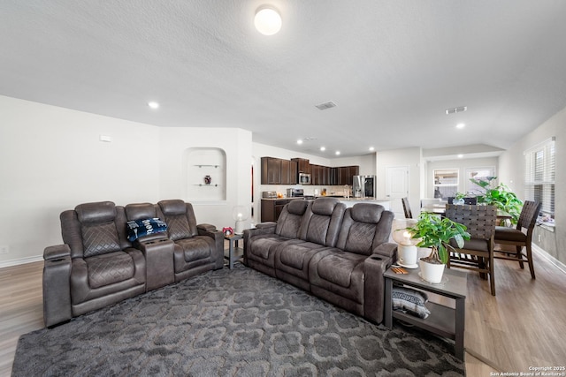 living area featuring light wood-style floors, recessed lighting, visible vents, and baseboards