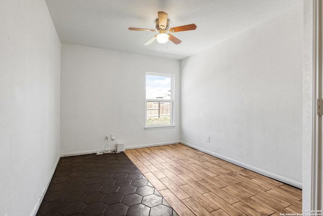 spare room with ceiling fan, baseboards, and wood finished floors