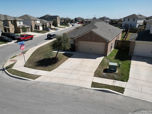 view of front of property featuring driveway, a garage, a residential view, fence, and brick siding