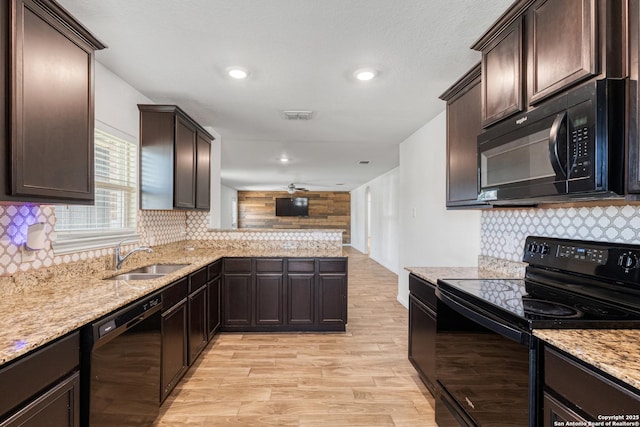 kitchen featuring black appliances, a sink, visible vents, and dark brown cabinetry