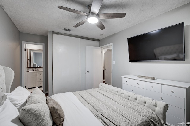 bedroom featuring a ceiling fan, a closet, visible vents, and a textured ceiling