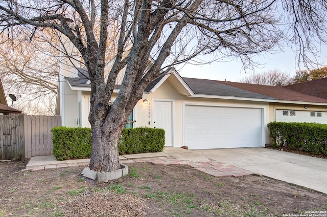 view of front of home featuring a garage, fence, concrete driveway, and stucco siding