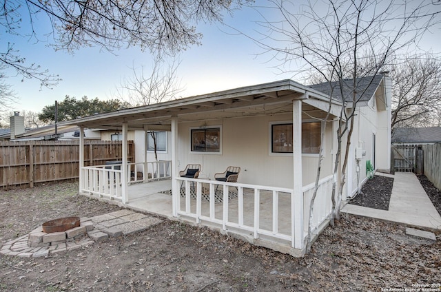 rear view of house with a patio, an outdoor fire pit, and a fenced backyard