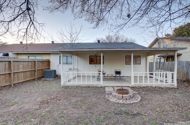 back of property featuring a fire pit, a patio, central AC unit, and a fenced backyard