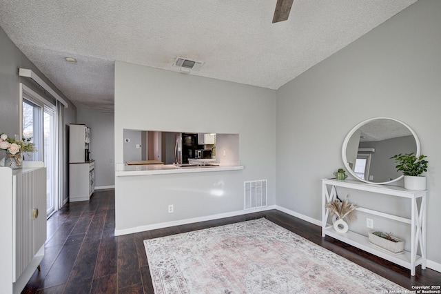 empty room with baseboards, visible vents, and wood finished floors