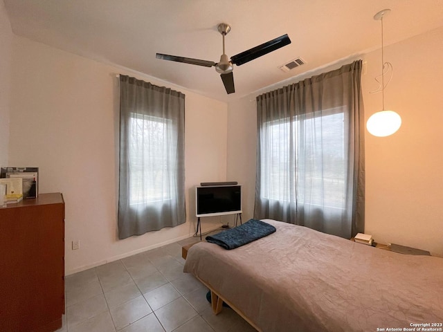 bedroom featuring a ceiling fan, tile patterned flooring, visible vents, and baseboards