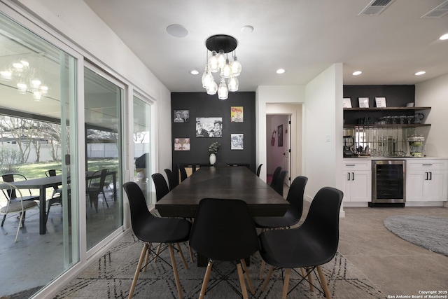 dining room featuring a bar, wine cooler, visible vents, and recessed lighting