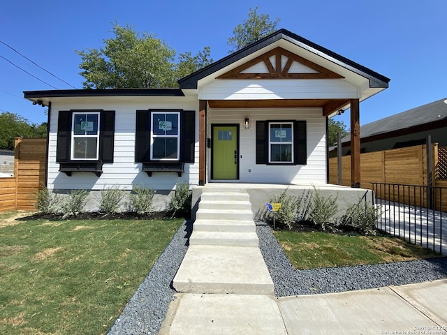 view of front of property with fence and a front lawn