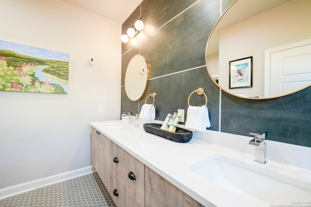 bathroom with a sink, baseboards, and double vanity