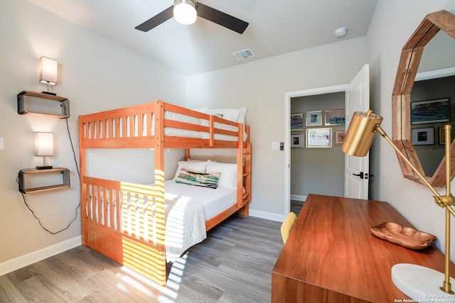 bedroom featuring ceiling fan, wood finished floors, visible vents, and baseboards