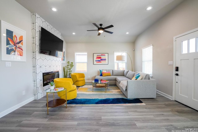 living room with recessed lighting, a fireplace, and wood finished floors