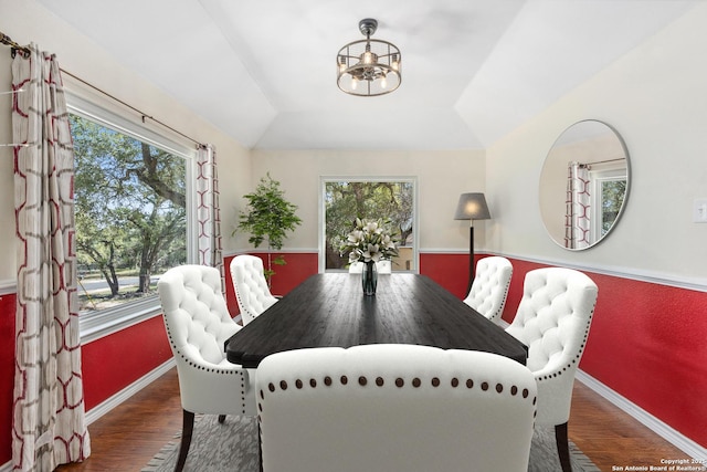 dining area with lofted ceiling, baseboards, wood finished floors, and a healthy amount of sunlight