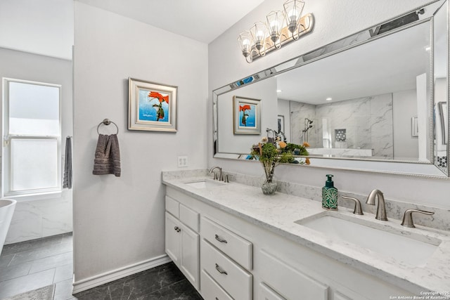 bathroom featuring double vanity, a marble finish shower, baseboards, and a sink