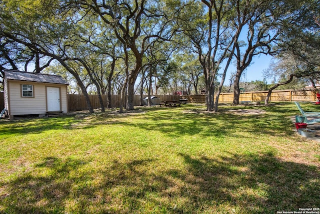 view of yard featuring a fenced backyard and an outbuilding