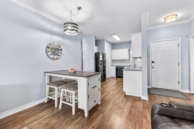 kitchen featuring white cabinets, black dishwasher, fridge with ice dispenser, decorative backsplash, and dark countertops