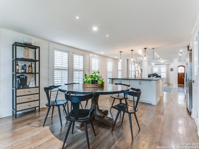 dining room featuring light wood-style flooring, recessed lighting, baseboards, and a healthy amount of sunlight