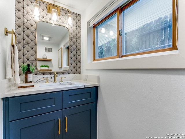 bathroom featuring visible vents, backsplash, and vanity