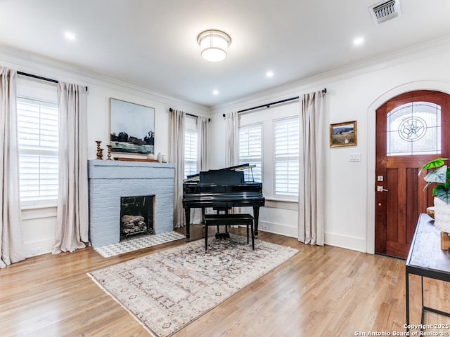 entryway featuring visible vents, ornamental molding, and wood finished floors