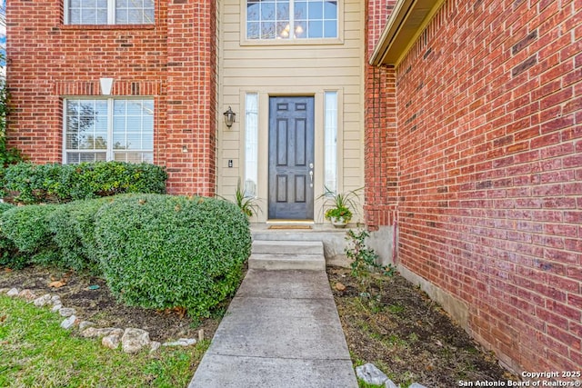 property entrance featuring brick siding