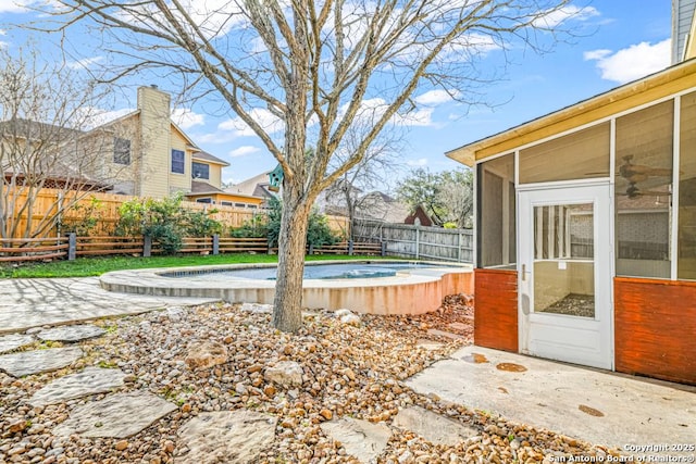 exterior space with a sunroom, a fenced backyard, a patio area, and a fenced in pool