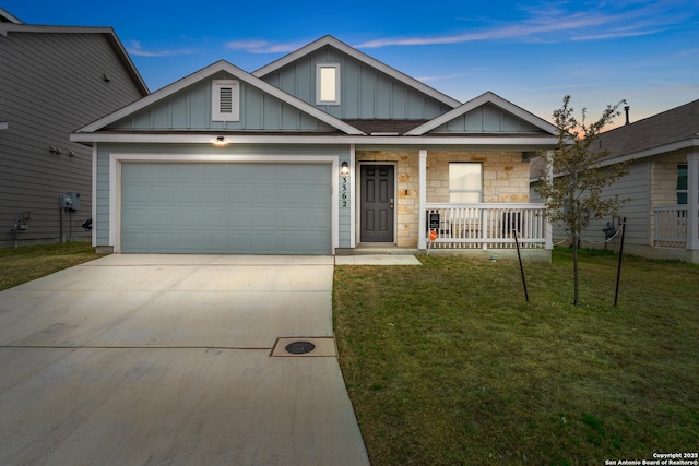 view of front of house featuring covered porch, concrete driveway, a lawn, an attached garage, and board and batten siding