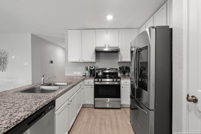 kitchen featuring stainless steel appliances, white cabinetry, a sink, light wood-type flooring, and under cabinet range hood