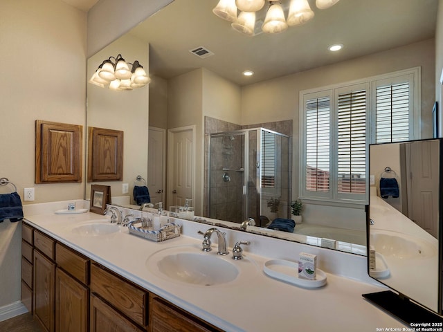 bathroom with double vanity, a stall shower, a sink, and visible vents