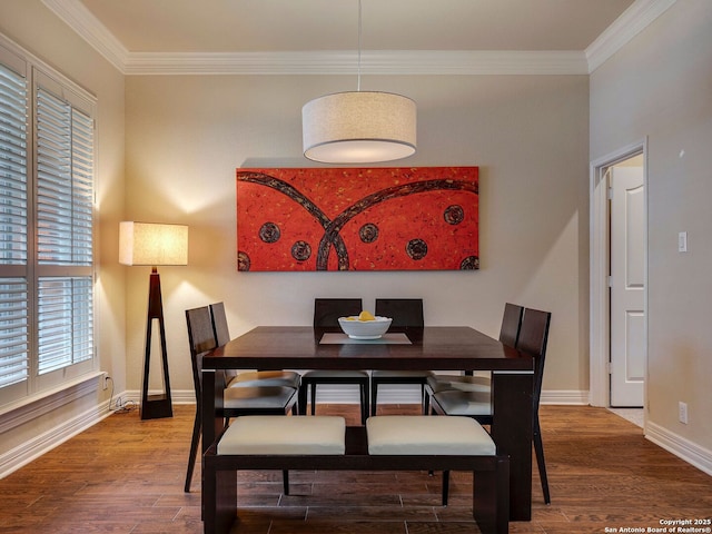 dining area with crown molding, baseboards, and wood finished floors