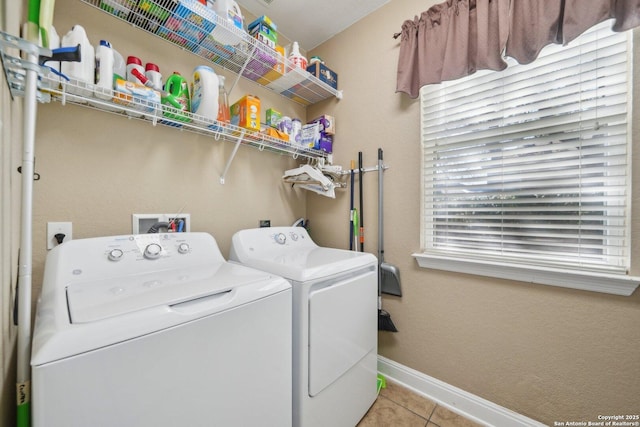 laundry area featuring baseboards, laundry area, independent washer and dryer, and tile patterned floors