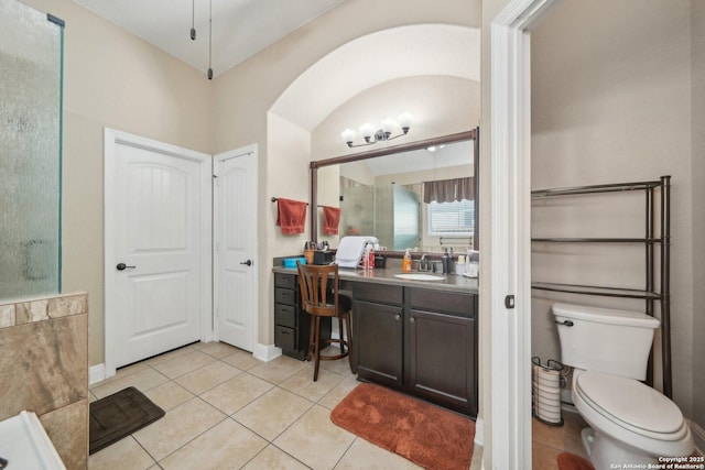 bathroom with tile patterned flooring, baseboards, vanity, and toilet