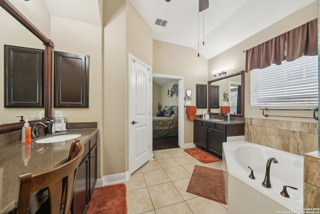 bathroom featuring vaulted ceiling, ensuite bath, tile patterned flooring, and a sink