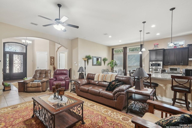 living area with arched walkways, a toaster, recessed lighting, visible vents, and light tile patterned flooring