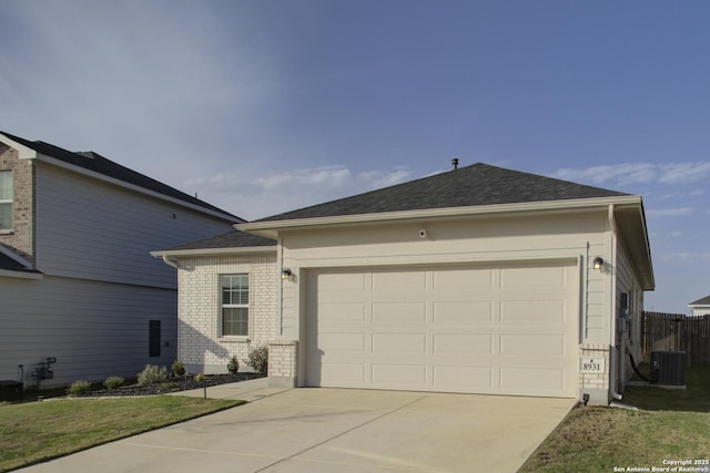 ranch-style house featuring an attached garage, central air condition unit, brick siding, driveway, and roof with shingles