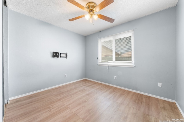 empty room featuring a textured ceiling, baseboards, and a ceiling fan