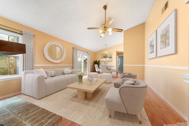 living area with a textured ceiling, plenty of natural light, wood finished floors, and visible vents