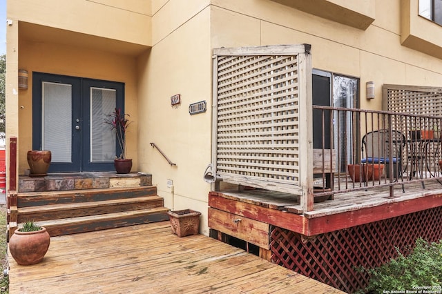 view of exterior entry featuring french doors and a deck