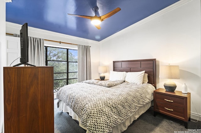 bedroom featuring ornamental molding, dark colored carpet, and a ceiling fan