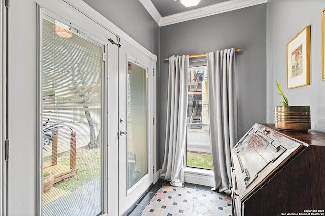 doorway with french doors, ornamental molding, and dark tile patterned floors